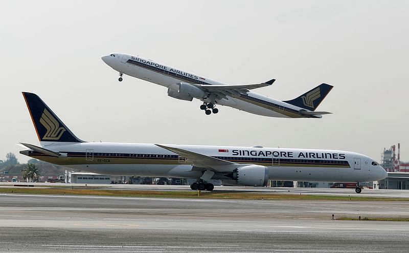 A Singapore Airlines Airbus A330-300 plane takes off behind a Boeing 787-10 Dreamliner at Changi Airport in Singapore 28 March 2018.