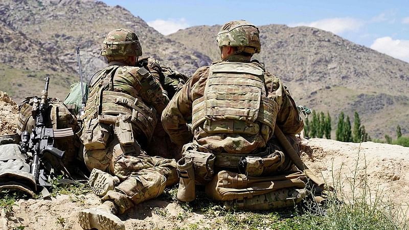 In this file photo taken on 6 June 2019, US soldiers look out over hillsides during a visit of the commander of US and NATO forces in Afghanistan general Scott Miller at the Afghan National Army (ANA) checkpoint in Nerkh district of Wardak province.