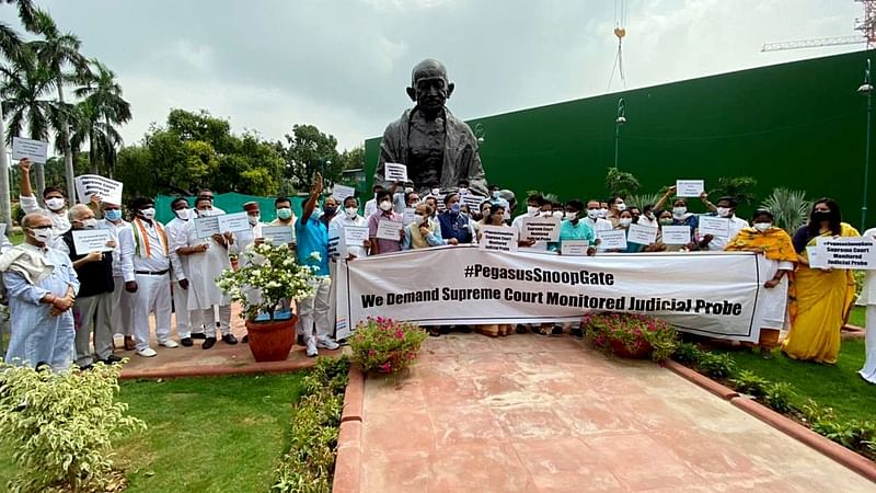 Lok Sabha MP Shashi Tharoor and Opposition party MPs hold placards during a protest against the Central Government over the Pegasus snooping issue in front of Gandhi Statue, in New Delhi on 23 July 2021