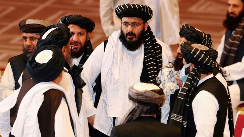 Taliban delegates speak during talks between the Afghan government and Taliban insurgents in Doha, Qatar on 12 September 2020