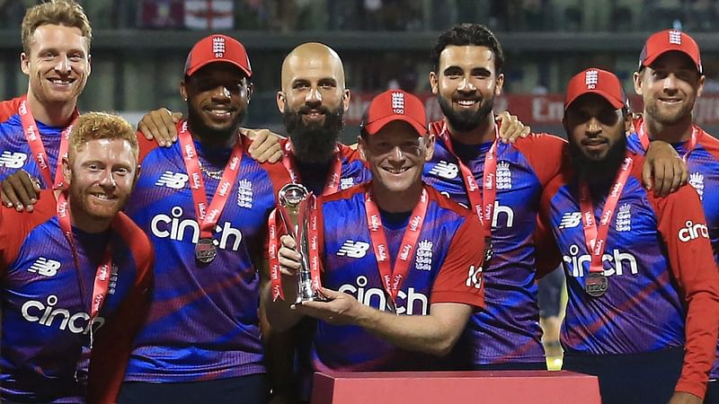 England's Captain Eoin Morgan (C), with teammates, raises the winner's trophy following the third T20 international cricket match between England and Pakistan at Old Trafford Cricket Ground in Manchester, northwest England, on 20 July, 2021.