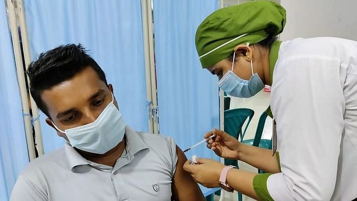 A nurse administers a Covid-19 vaccine to a man at Dhaka Medical College Hospital