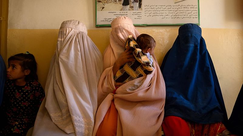 In this picture taken on 1 October 2020, women wait with their children at a government-run maternity clinic in a rural area of Dand district in Kandahar province