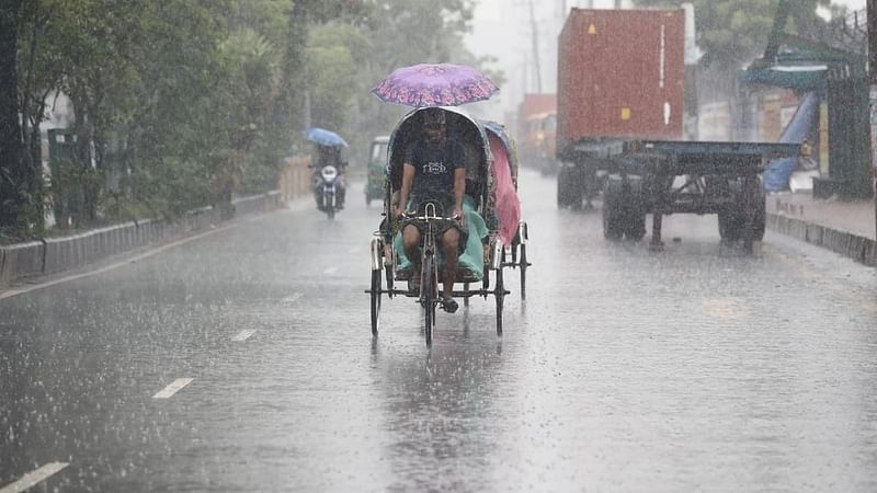 A rickshaw puller pulls rickshaw amid rain in Dhaka