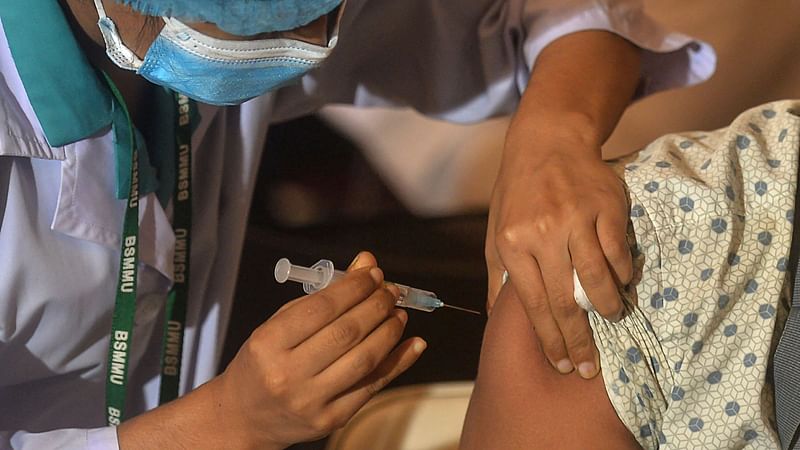 In this photo a health worker inoculates a man with a dose of the Oxford-AstraZeneca Covid-19 vaccine at the Bangabandhu Sheikh Mujib Medical University Hospital (BSMMU), in Dhaka on 22 June 2021.