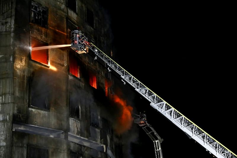 Firefighters work at the scene of the fire that broke out the Hashem Foods factory in Rupganj of Narayanganj district on the outskirts of Dhaka, Bangladesh, on 9 July 2021