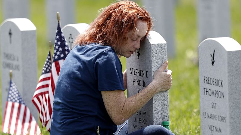 Maria Velez of Orlando, Florida, hugs the tombstone of her son Stephen at the Ohio Western Reserve National Cemetery on Memorial Day, during the global outbreak of the coronavirus disease (COVID-19), in Seville, Ohio, US on 25 May 2020