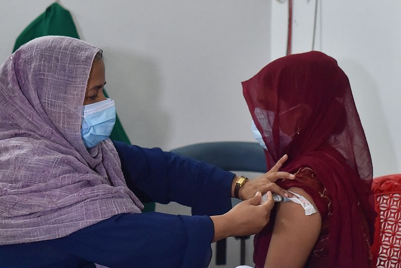 A health official inoculates a sex worker with the dose of Sinopharm vaccine against the Covid-19 during a special vaccination drive at Daulatdia