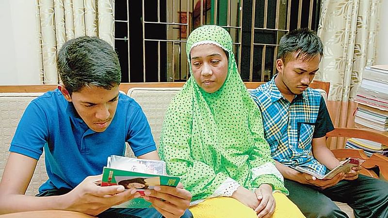 Tasin Mahmud (left) and Mahmud Arabi have lost their father, the only earning member of the family. Their mother Arifa Sultana is at a loss of about her sons’ future. The boys look at their father’s pictures. Friday, at their home in Rampura, Dhaka.