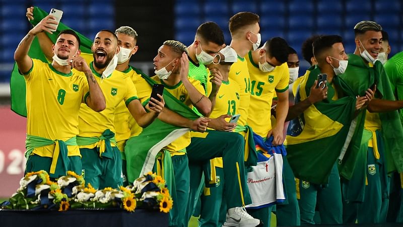 Brazil's gold medallists celebrate before getting on the podium during the medal ceremony of the Tokyo 2020 Olympic Games men's football competition at Yokohama International Stadium in Yokohama, Japan, on 7 August 2021.