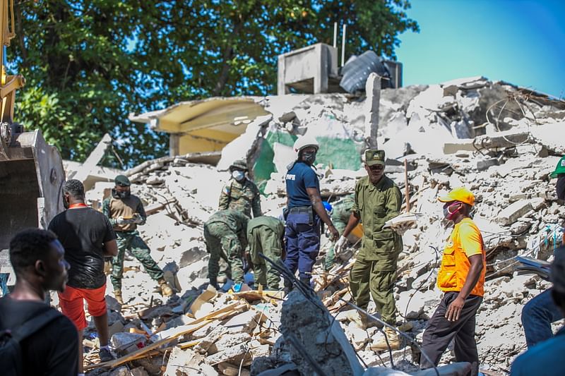 Soldiers and members of a rescue and protection team clean debris from a house after a 7.2 magnitude earthquake in Les Cayes, Haiti 15 August , 2021