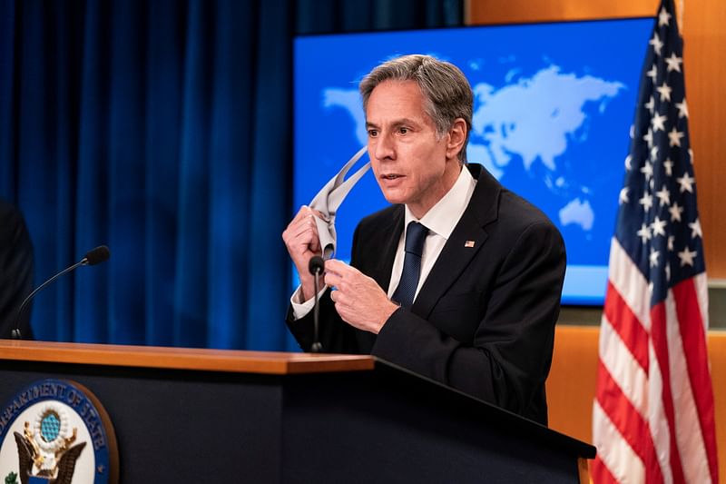 US Secretary of State Antony Blinken removes his protective face mask during a media briefing on Afghanistan, at the State Department, in Washington, DC, US on 25 August  2021