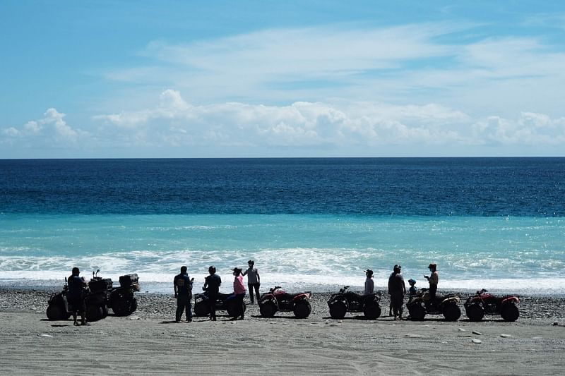 Tourists visit the beach in Fenniaolin, Yilan county as Typhoon Chanthu approaches the southeast of Taiwan on 10 September 2021