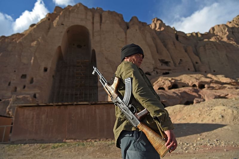 In this file photo taken on 3 March 2021, a policeman patrols the site where the statues of Buddha stood in Bamiyan before being destroyed by the Taliban in March 2001.