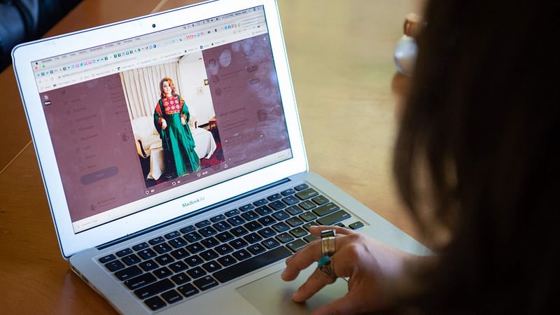 Bahar Jalali, an Afghan academic, looks at her Twitter account as she speaks with AFP during an interview in her home in Glenwood, Maryland, 24 September, 2021