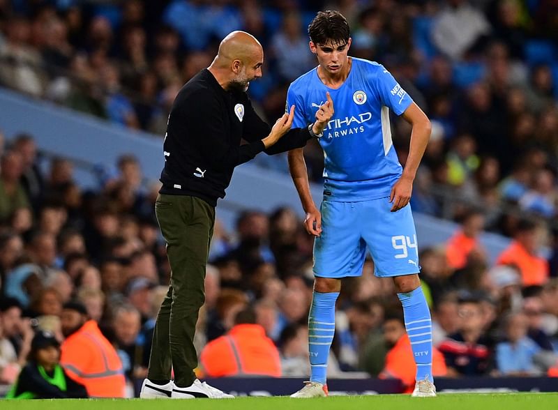 Manchester City's Spanish manager Pep Guardiola gives instructions to Manchester City's English defender Finley Burns during the English League Cup third round football match between Manchester City and Wycombe Wanderers at the Etihad stadium in Manchester, northwest England on 21 September, 2021