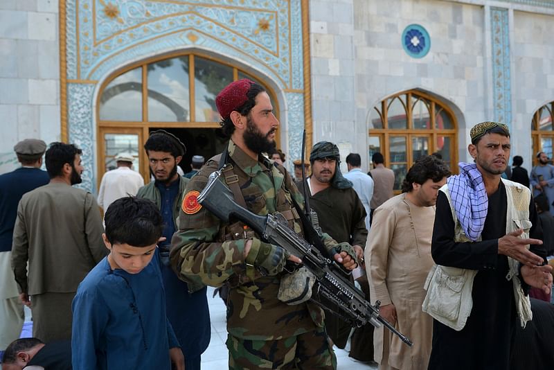 An armed Taliban fighter stands guard as devotees leave after Friday prayers at the Pul-e Khishti Mosque in Kabul on 3 September 2021