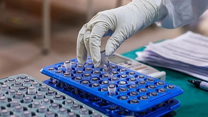 A health worker in a Dhaka hospital sorts test tubes with samples for testing novel coronavirus infection