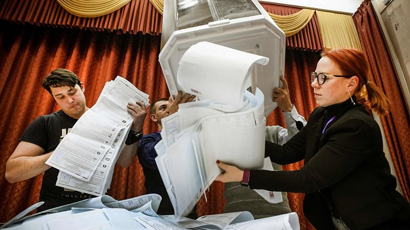 Members of a local electoral commission empty a ballot box at a polling station after the last day of the three-day parliamentary election, in Moscow, on 19 September, 2021