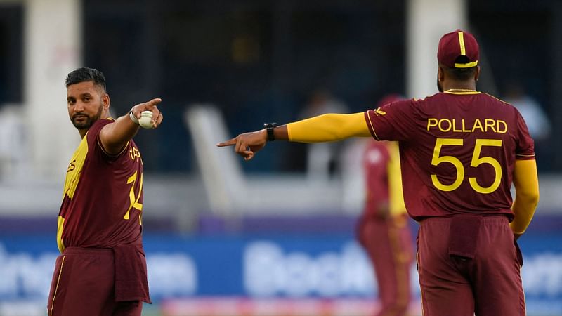 West Indies' captain Kieron Pollard (R) and Ravi Rampaul (L) adjust the field during the ICC men’s Twenty20 World Cup cricket match between South Africa and West Indies at the Dubai International Cricket Stadium in Dubai on 26 October 2021.