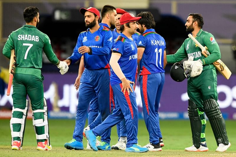 Pakistan's Asif Ali (R) and teammate Shadab Khan (L) shake hands with Afghanistan's players at the end of the ICC men’s Twenty20 World Cup cricket match between Afghanistan and Pakistan at the Dubai International Cricket Stadium in Dubai on 29 October, 2021