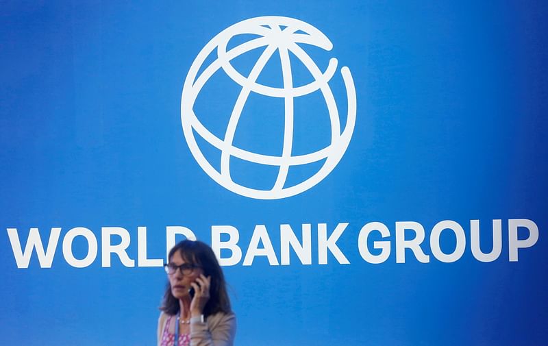 A participant stands near a logo of World Bank at the International Monetary Fund - World Bank Annual Meeting 2018 in Nusa Dua, Bali, Indonesia on 12 October 2018.