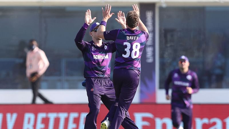 Scotland's Josh Davey celebrates (C) with teammates after the dismissal of Papua New Guinea's captain Assad Vala (not pictured) during the ICC men’s Twenty20 World Cup cricket match between Scotland and Papua New Guinea at the Oman Cricket Academy Ground in Muscat on 19 October 2021.