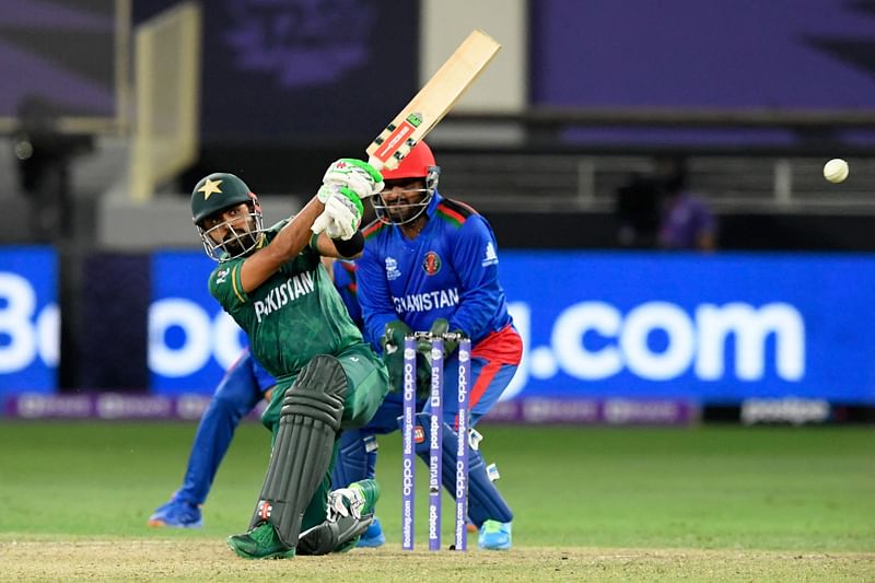 Pakistan's captain Babar Azam (L) plays a shot as Afghanistan's wicketkeeper Mohammad Shahzad watches during the ICC men’s Twenty20 World Cup cricket match between Afghanistan and Pakistan at the Dubai International Cricket Stadium in Dubai on 29 October, 2021