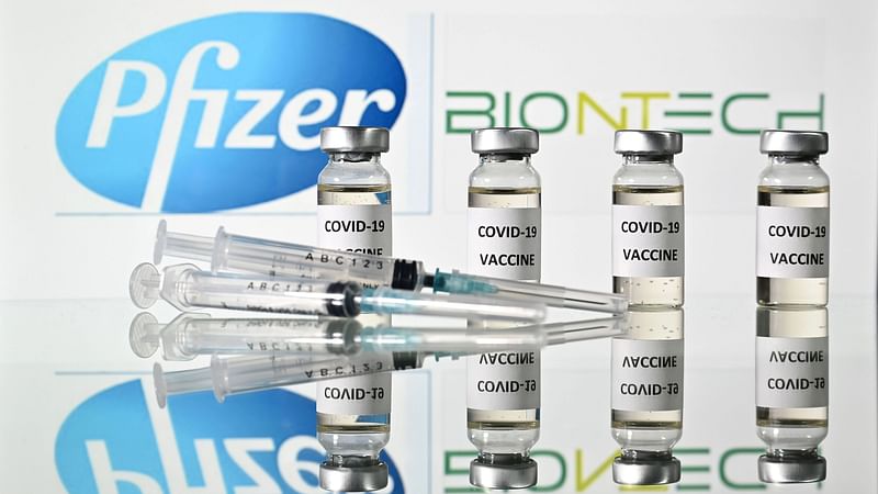 In this file illustration photo taken on 17 November 2020 are pictured vials with Covid-19 Vaccine stickers attached and syringes with the logo of US pharmaceutical company Pfizer and German partner BioNTech