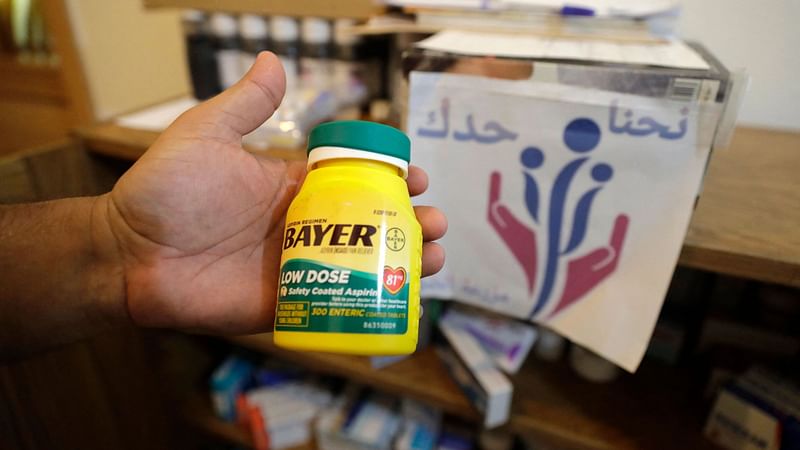 In this file photo taken on 12 July 2021 a Lebanese volunteer of the "We Are By Your Side" initiative handles a box of low dose Aspirin (acetylsalicylic acid) medication in the village of Mazraat el-Dahr in Mount Lebanon province, south of the capital, where medications are obtained from nationals arriving from abroad and stored to be distributed to those who need them free of charge