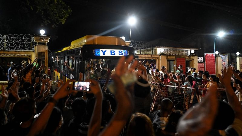 Yangon, Yangon division : Newly-released prisoners wave from a bus as they depart the Insein Prison in Yangon on 18 October, 2021