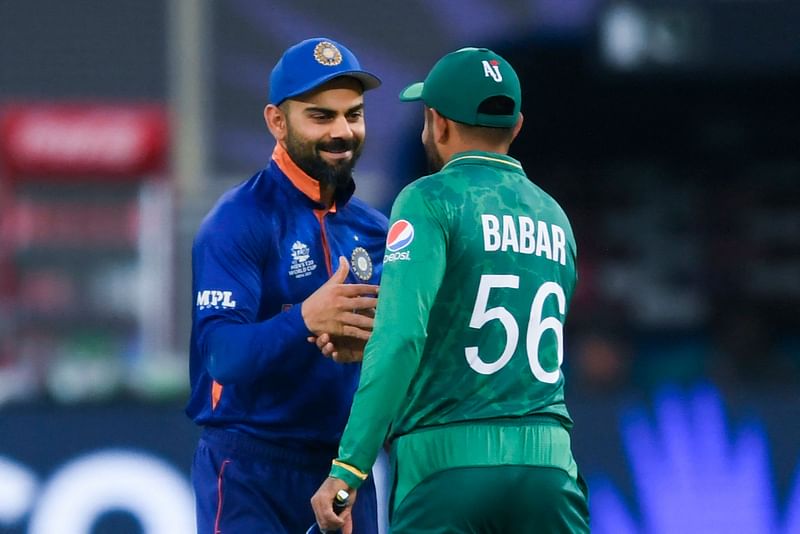 India's captain Virat Kohli (L) and his Pakistan's counterpart Babar Azam greet each other before the start of the ICC men’s Twenty20 World Cup cricket match between India and Pakistan at the Dubai International Cricket Stadium in Dubai on October 24, 2021.