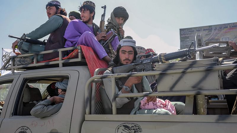 Taliban members drive along a road in the centre of Kabul on 14 October 2021