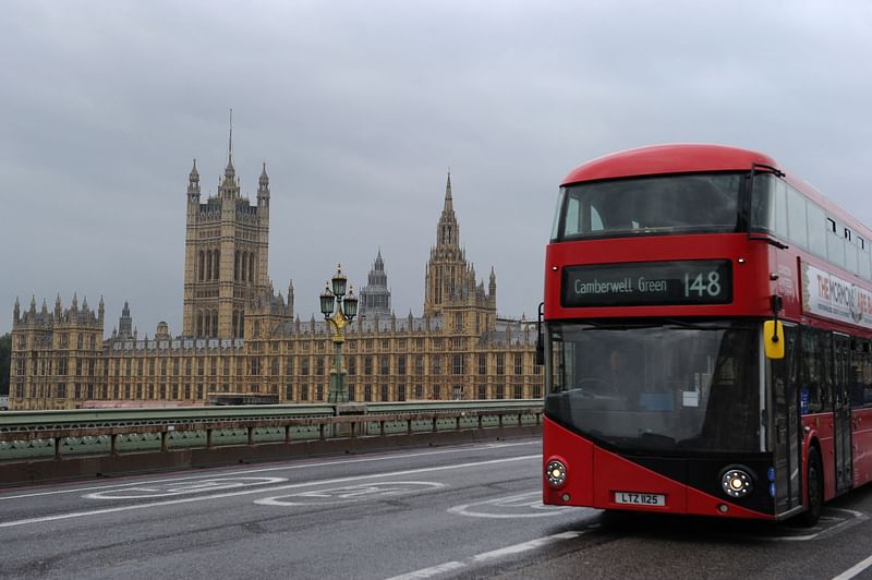 A bus is driven on Westminster Bridge past the Houses of Parliament in central London on 16 October 2021.