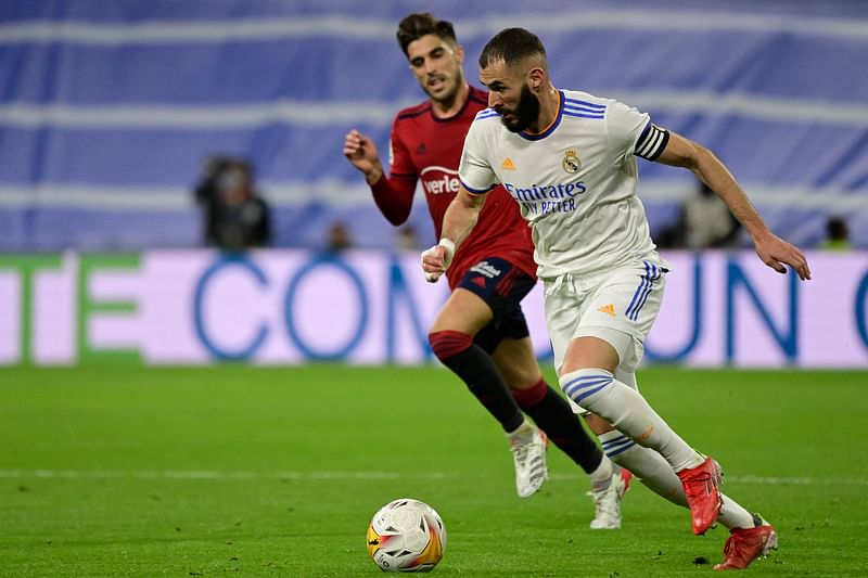 Real Madrid's French forward Karim Benzema runs with the ball during the Spanish League football match between Real Madrid CF and CA Osasuna at the Santiago Bernabeu stadium in Madrid on 2October, 2021