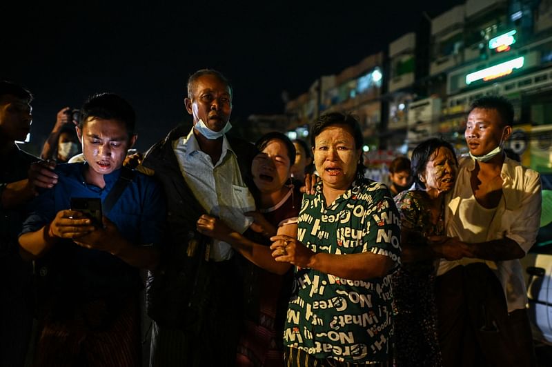 People react as they are reunited with their family members outside the Insein Prison following her release in Yangon on 18 October, 2021