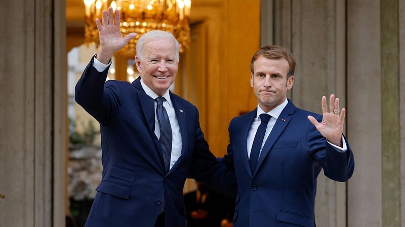 French President Emmanuel Macron (R) welcomes US President Joe Biden (L) before their meeting at the French Embassy to the Vatican in Rome on 29 October 2021