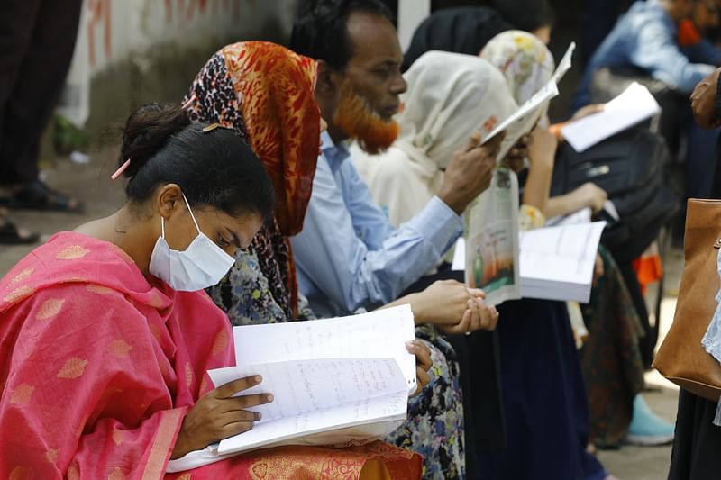 A goveremnt job seeker takes the last-minute preparation sitting in front of the examination centre. The picture was taken from the Dhaka University area on 29 October 2021.