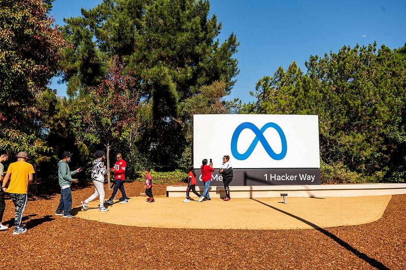 People visit a newly unveiled logo for "Meta", the new name for Facebook's parent company, outside Facebook headquarters in Menlo Park on 28 October 2021