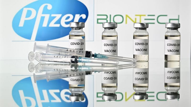 In this file illustration photo taken on 17 November 2020 are pictured vials with Covid-19 Vaccine stickers attached and syringes with the logo of US pharmaceutical company Pfizer and German partner BioNTech