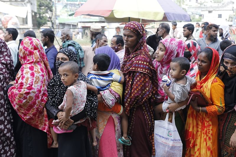 People wait in long queues to purchase necessary commodities from TCB at fair prices. The picture was taken from Mohammadpur bus station on 3 November.