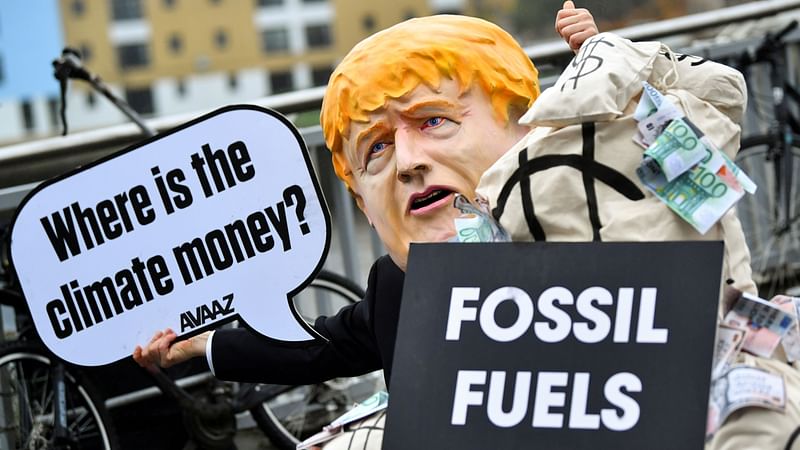 A person wearing a mask depicting Britain's Prime Minister Boris Johnson protests during the UN Climate Change Conference (COP26) in Glasgow, Scotland, Britain on 12 November 2021