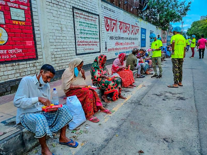 Volunteers of Bhalo Kajer Hotel distribute food among people in Kamalapur Railway Station area