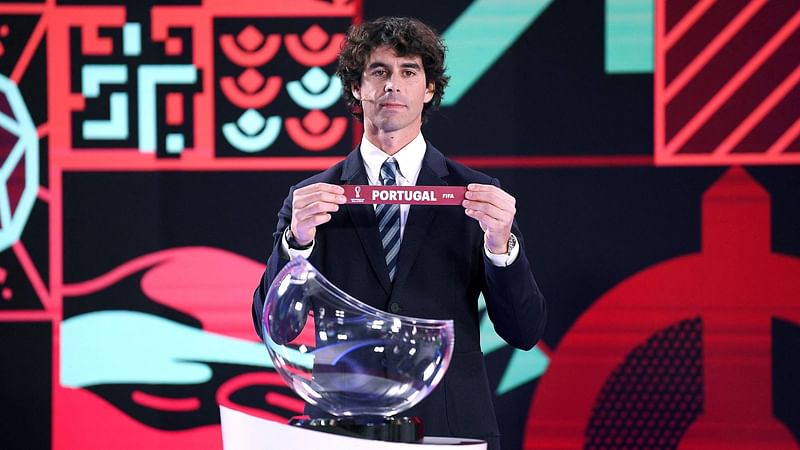 This handout photo taken and released by FIFA on 26 November, 2021, shows Portuguese former football player Tiago holding the slip for Portugal during the draw for the European and Intercontinental play-offs for the FIFA World Cup Qatar 2022 football tourament, in Zurich