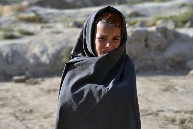 A child poses for a picture early in the morning in Kandahar on 21 November, 2021