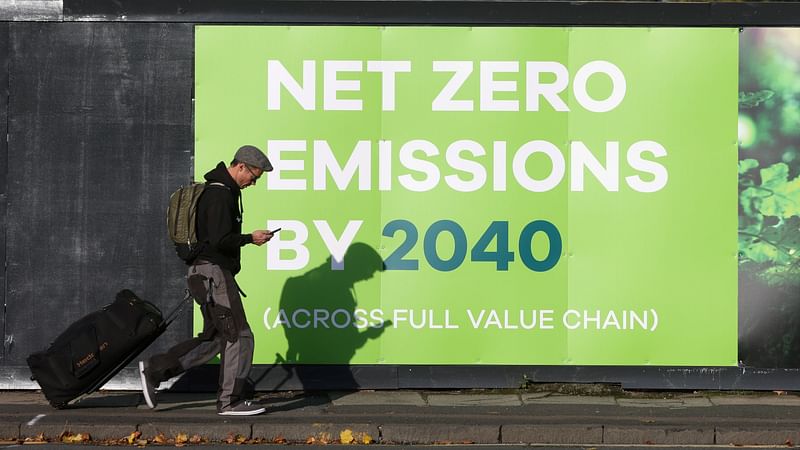 A man walks past a advertising in relation with the UN Climate Change Conference (COP26) where world leaders discuss how to tackle climate change on a global scale, near the conference area in Glasgow Scotland, Britain on 30 October 2021.