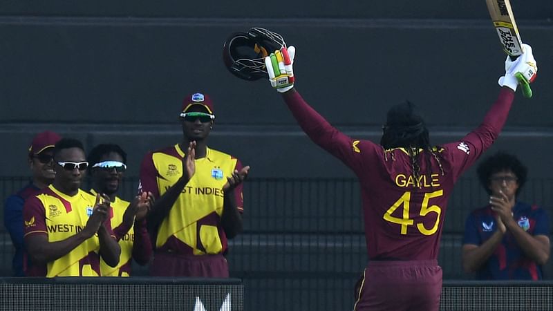 West Indies' Chris Gayle raises his hands as he is being greeted by his teammates after his dismissal during the ICC men’s Twenty20 World Cup cricket match between Australia and West Indies at the Sheikh Zayed Cricket Stadium in Abu Dhabi on 6 November 2021.