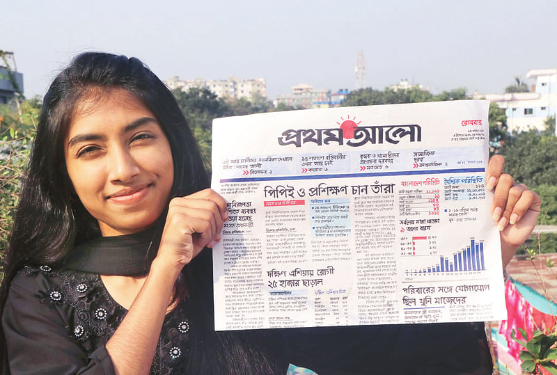 A student of Bagura Government Azizul Haque College, Nurani Islam Nisa with a copy of Prothom Alo drawn and written by hand, poses for the camera