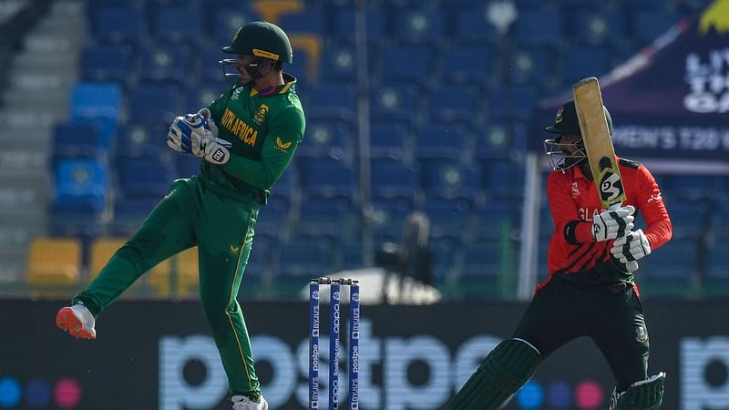 Bangladesh's Liton Das (R) plays a shot as South Africa's wicketkeeper Quinton de Kock reacts during the ICC men’s Twenty20 World Cup cricket match between South Africa and Bangladesh at the Sheikh Zayed Cricket Stadium in Abu Dhabi on 2 November 2021.