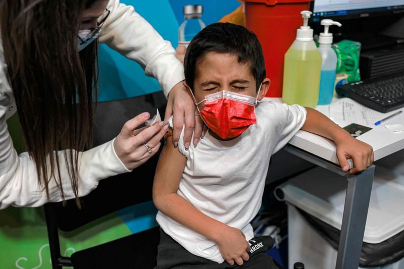 An health worker administers a dose of the Pfizer/BioNTech Covid-19 vaccine to a six-year-old child